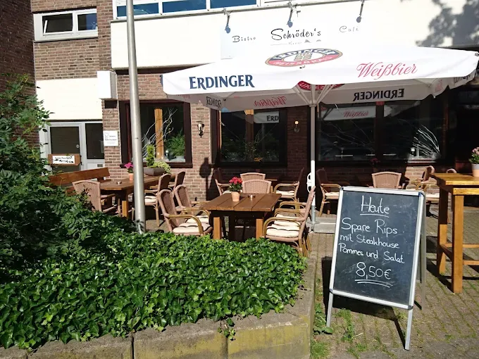Terrasse des Bistro Schröders mit Sonnenschirm und Kreidetafel am Tag